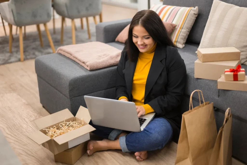 mulher-sentada-no-chao-cercada-de-sacolas-com-o-laptop-no-colo-plataforma de vendas online