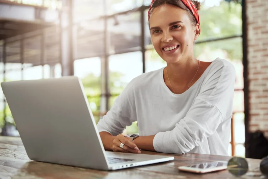 mulher sorrindo trabalhando em frente ao computador como vender um produto