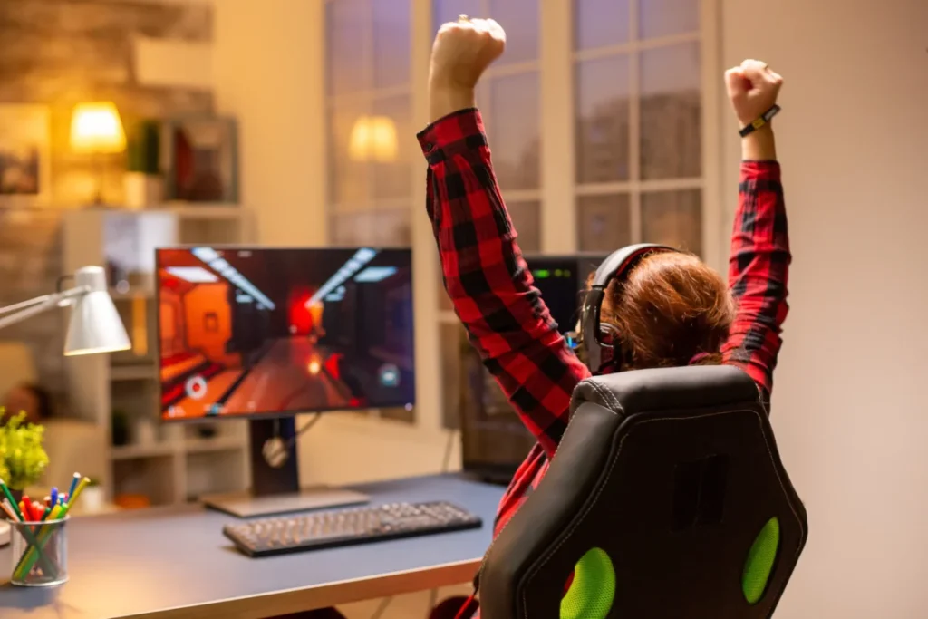 vista de costas de pessoa sentada jogando no computador gamer - infoprodutos mais vendidos